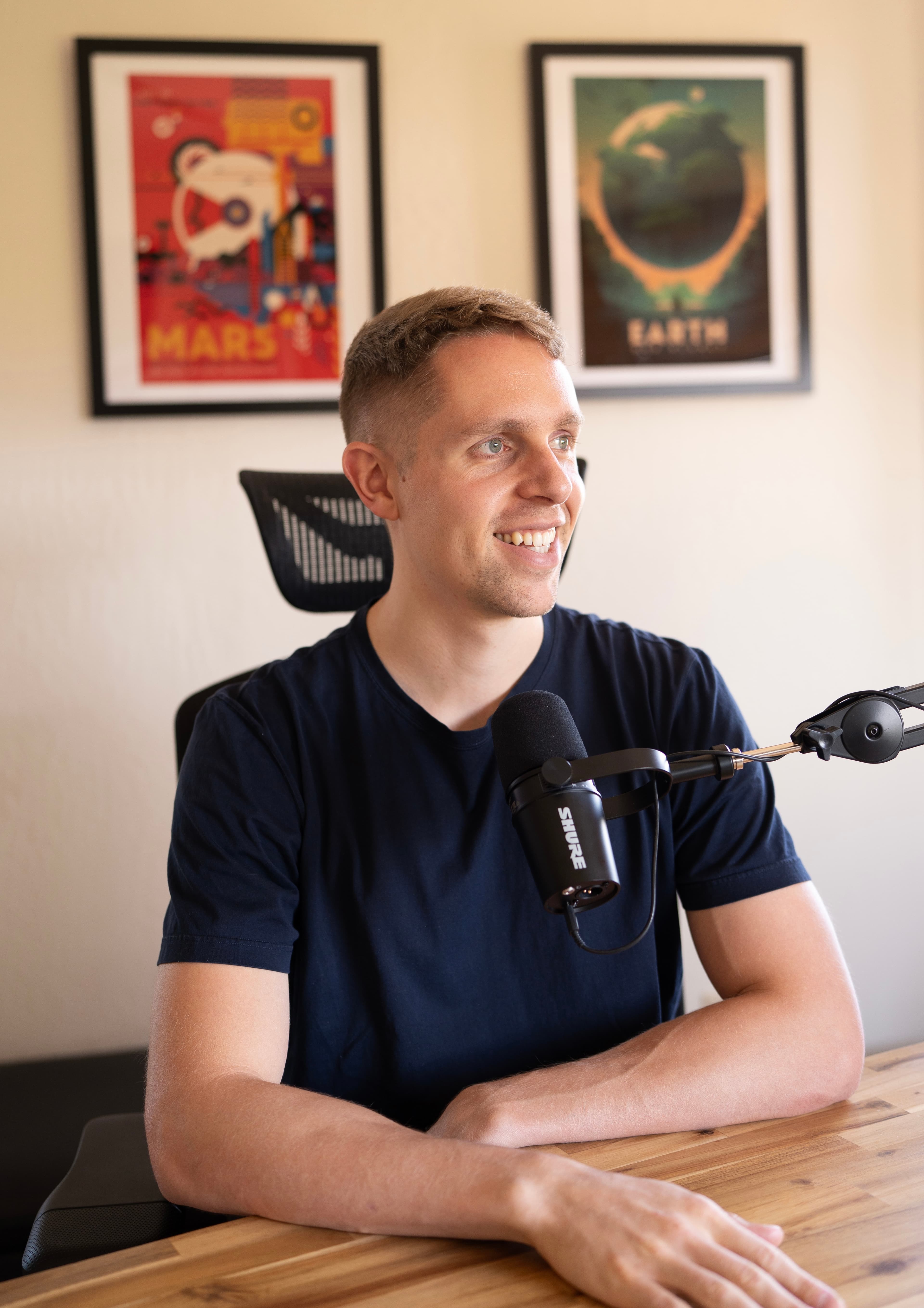 Podcast host seated at a microphone